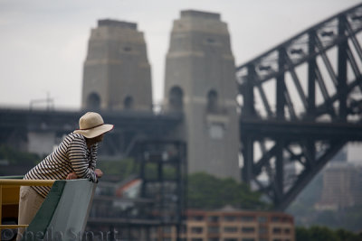 Woman in hat on Manly ferry with Sydney Harbour Bridge backdrop