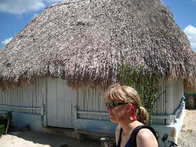 Julie walking by a Mayan hut