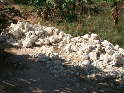 piles of rocks that have to be broken down into smaller pieces for the wall