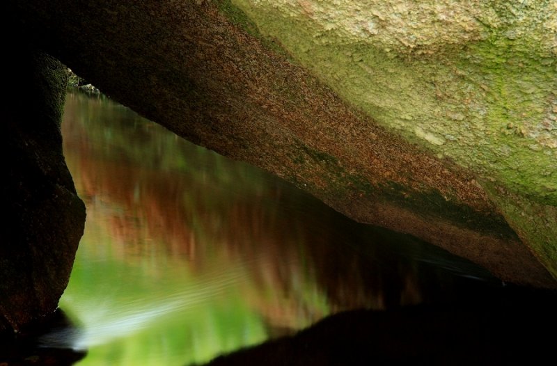 Abstract - stream flowing under granite boulders