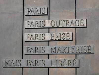 Plaque at the base of the CDG statue
