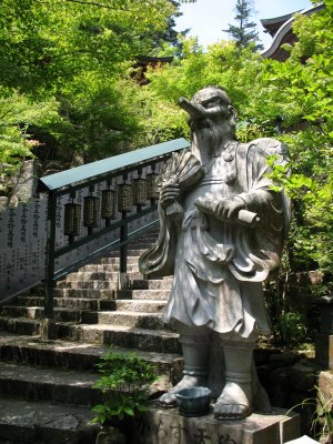 Tengu statue beside steps to Maniden