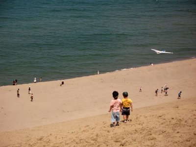 Young kids running down the sandy slope