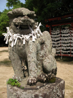Omikuji draped around a shrine statue