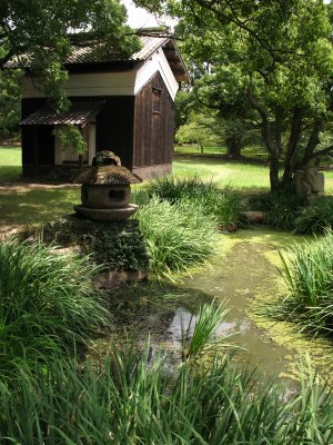 Stone lantern and hut beside a marshy pond