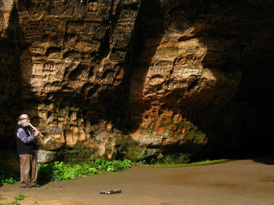 Recorder-playing local outside Gūtmaņis Cave