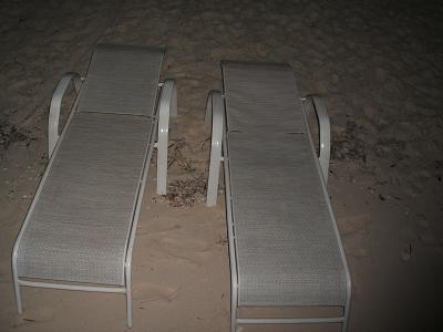 chaise lounge chairs on the beach at night