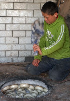 Boy Making Bagels in Old Clay Oven