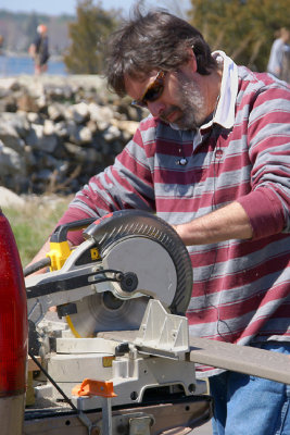 Volunteer with cut-off saw.