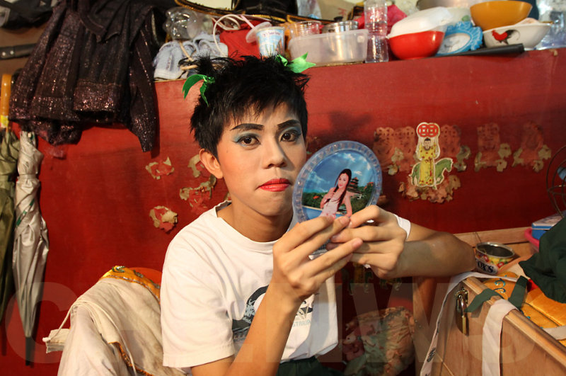 A young actor does his own make-up before the show.