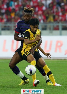Alex Song shielded by a Malaysian player
