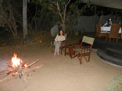 We sit by the fire to enjoy Amarula while dinner is prepared