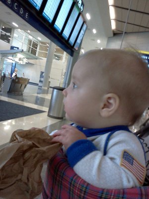 Annie checks flight info at DFW