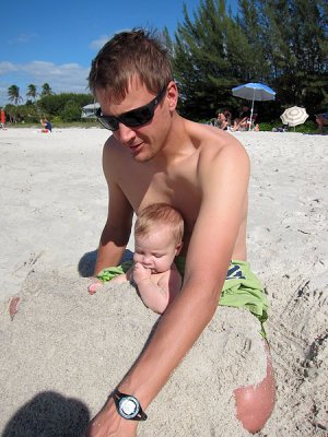 Daddy buries the rest of Annie in sand