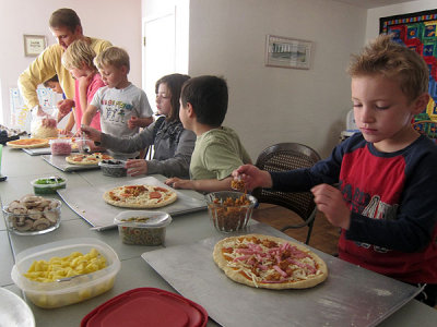 Kids making pizza for party lunch