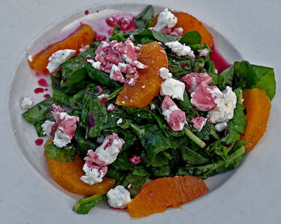 Arugula with orange slices, goat cheese, and pomegranate sauce