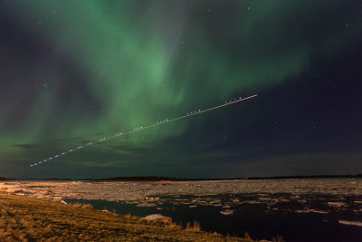 Aircraft passing in front of Northern Lights at Moosonee 2012 April 12th