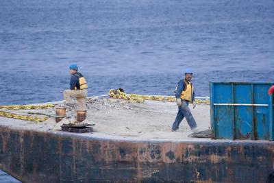 Crew members near bow of towed barge
