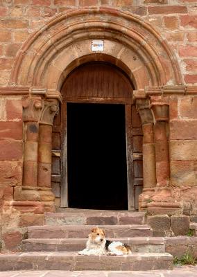 Dog at the romanesque door - Pineda