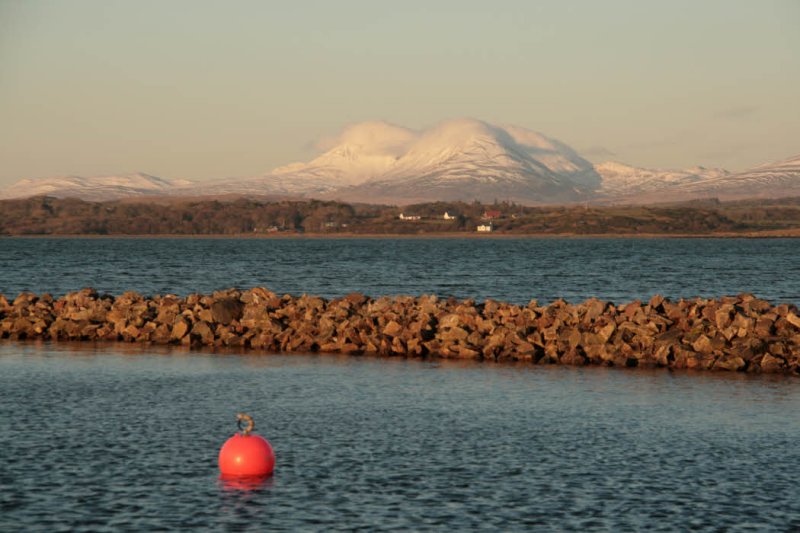Sunset at Bowmore harbour with the Paps of Jura in the distance