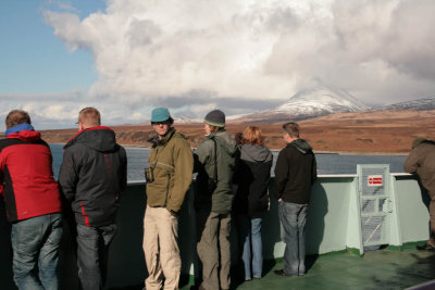 Braving the wind on the front deck of the ferry in the Sound of islay with the snow covered hills of Jura behind