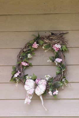 The robin isn't a decoration! Barbara, a volunteer for the Feather, had this robin make her nest right by her front door.