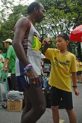 A young volunteer marking off the number tags at the finishing line