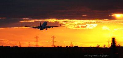 Plane takes off at Ottawa International airport into late day sun