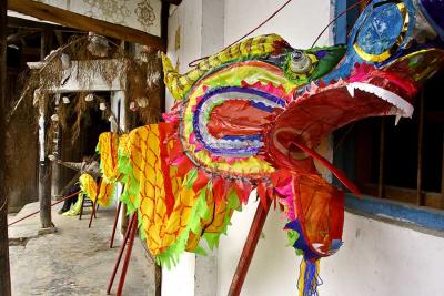Sewing on the dragon tail for the New Year celebration. Pan Zhai Village, Guizhou, China