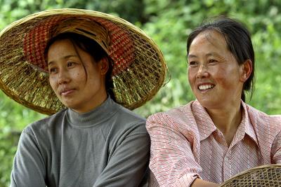 Two women relaxing in the shade on a hot and humid day. Ping Shan Po Village, Wuling Mts, Hunan, China