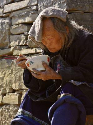 Shading herself with a towel, this elderly woman ate her evening meal. On closer observation I noticed she was very blind.