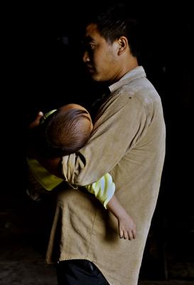 Father and sleeping child. Remote village China. 2006