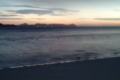 Sunrise at Koh Hae. Lights from Phuket Island seen in the distance.