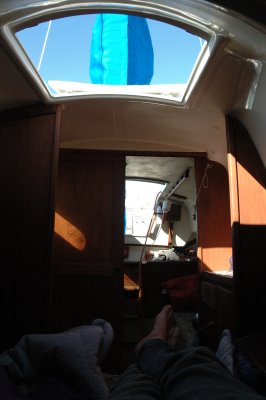 lying in bed, looking out the hatch at the rest of the cabin and the mast