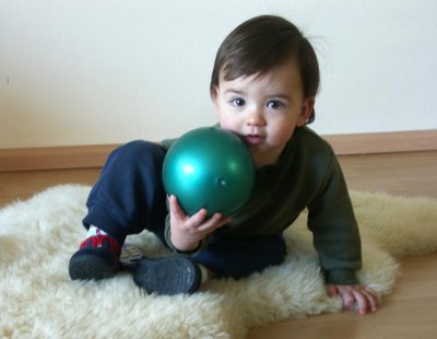 A green ball, a white rug, and Charlie