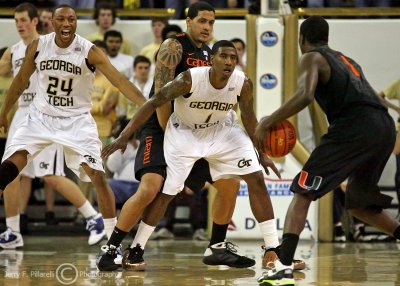 Jackets G Shumpert fights off a screen to stay with Canes G Scott as GT F Kammeon Holsey shouts a warning