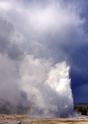 Old Faithful Geyser recedes in a rain storm in Yellowstone National Park