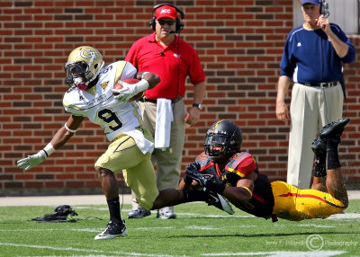 Georgia Tech A-back Tony Zenon gets tripped up by Maryland DB Trenton Hughes