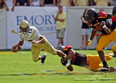 Jackets QB Washington gets dragged down by a Terrapins defender