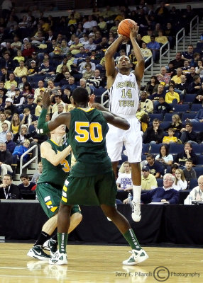 Tech G Morris takes a three point shot over two Saints defenders