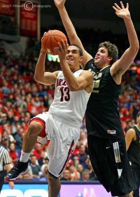 Wildcats G Johnson drives to the basket around Golden Grizzly C Petros…
