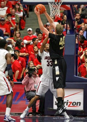 Wildcats F Perry stands his ground on defense against Golden Grizzly C Kyle Sikora