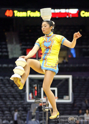 …Unicyclist sets up her bowl act during halftime…
