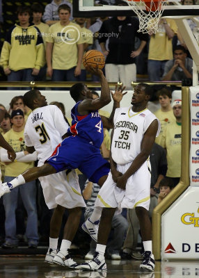 Kansas G Sherron Collins slices his way through two Tech defenders on the way to the basket