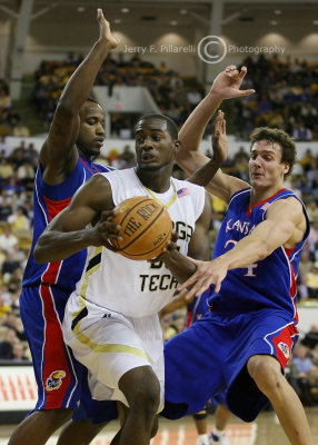 Georgia Tech F Peacock looks to pass while being hounded by Kansas defenders