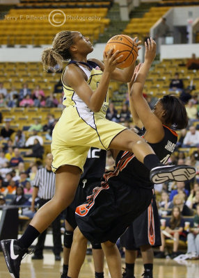 Yellow Jackets F Janie Mitchell drives over Hurricanes F Lamese James