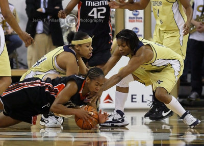Jackets Hemingway and Williams attempt to grab a loose ball from a diving Miami player