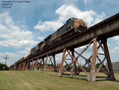 The jucie train passes over a worker weed eating the grass at Weldon.tif