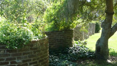 An undulating brick wall, in front of the house.