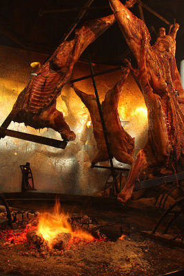 Lamb roasting over fire pit, El Calafate
